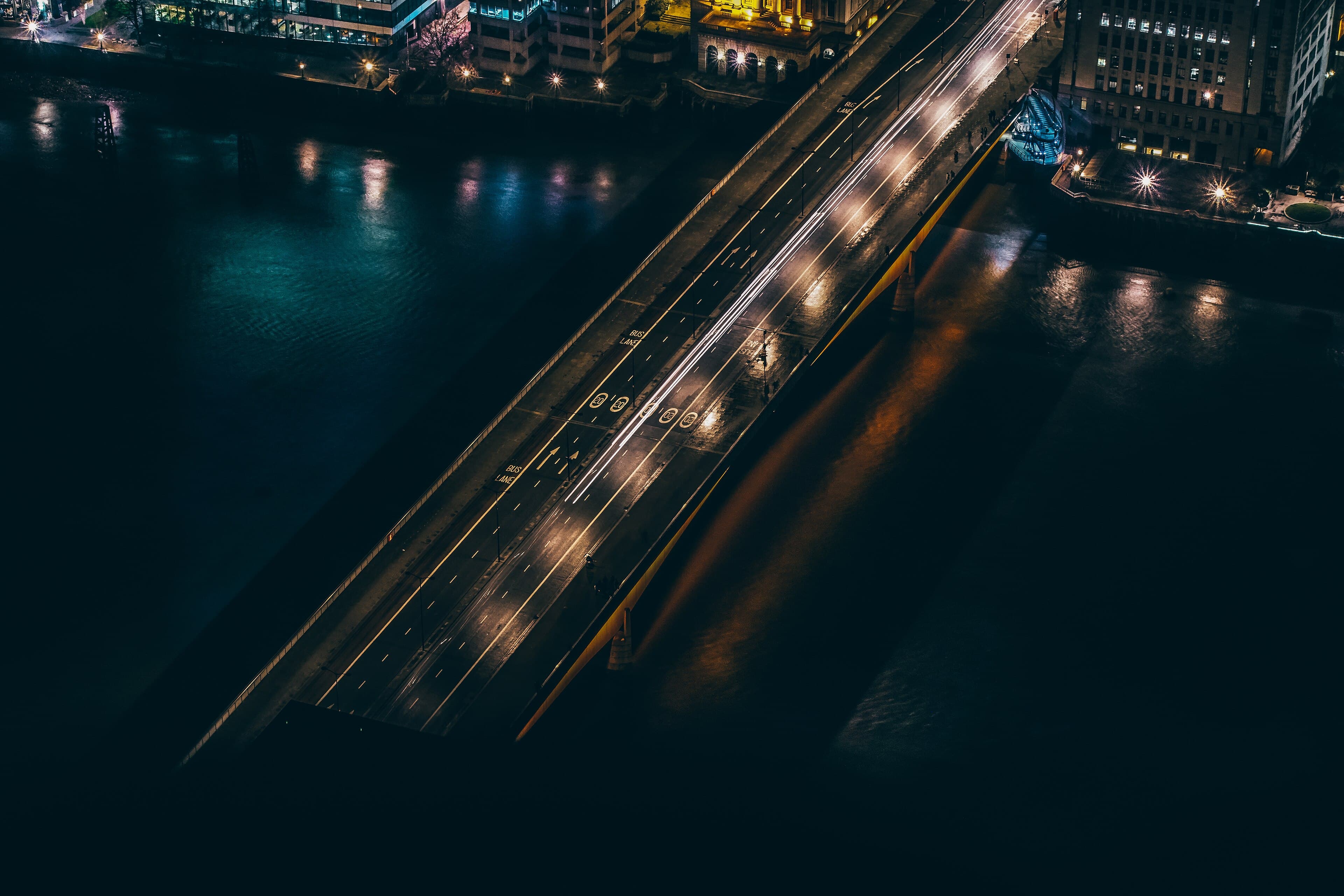 Eine Brücke mit fahrenden Fahrzeugen bei Nacht, von oben gesehen.